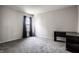 Bright, carpeted bedroom features a window with dark curtains and a black desk for functionality at 12596 Autumn Gate Way, Carmel, IN 46033