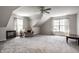 Spacious carpeted bonus room with vaulted ceiling, neutral walls, and natural light from two windows at 12596 Autumn Gate Way, Carmel, IN 46033
