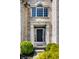 Close-up of a home's front door showcasing the detailed brickwork and manicured landscaping at 12596 Autumn Gate Way, Carmel, IN 46033