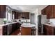 Modern kitchen with dark wood cabinets, stainless steel appliances, and a center island with seating at 12596 Autumn Gate Way, Carmel, IN 46033