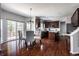 Open floor plan showcasing hardwood floors, a dining table, chairs, and dark kitchen cabinets at 12596 Autumn Gate Way, Carmel, IN 46033