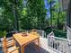 A wooden deck with a dining table and view of the mature trees at 13650 Golden Ridge Ln, Fishers, IN 46055