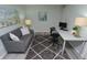 Bright home office features a gray couch, desk and modern gray vinyl flooring at 1442 N Illinois St # 19, Indianapolis, IN 46202