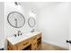 Stylish bathroom with a double vanity, round mirrors, and modern lighting fixtures at 1600 S Morgantown Rd, Morgantown, IN 46160