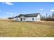 Modern farmhouse with black metal roof and bright white siding surrounded by green grass and blue sky at 1600 S Morgantown Rd, Morgantown, IN 46160