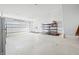 Bright garage featuring roll up door and storage rack with shelves for organization at 1600 S Morgantown Rd, Morgantown, IN 46160