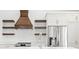 Modern kitchen with white cabinets, stainless steel appliances, a stylish range hood, and floating shelves at 1600 S Morgantown Rd, Morgantown, IN 46160