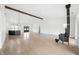 Open living space with wood beam accent, modern lighting, fireplace, and kitchen with center island at 1600 S Morgantown Rd, Morgantown, IN 46160