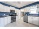 Kitchen with white cabinets, dark blue walls, and stainless steel appliances at 202 Noble St, Greenwood, IN 46142