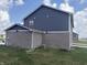 Gray home displays brick side, siding, and the grassy backyard at 251 Dyson Dr, Whiteland, IN 46184