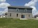 Gray home shows rear brick elevation and siding, plus the grassy backyard at 251 Dyson Dr, Whiteland, IN 46184