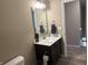 Bathroom with dark wood vanity, white sink, and a view into the hallway at 251 Dyson Dr, Whiteland, IN 46184