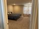 Carpeted bedroom with a queen bed, neutral walls, and decorative curtains at 251 Dyson Dr, Whiteland, IN 46184