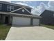 A gray home displays its front elevation and driveway, leading to the two-car attached garage at 251 Dyson Dr, Whiteland, IN 46184