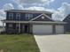 Two-story home boasts gray siding and a brick facade, complemented by a spacious, two-car garage at 251 Dyson Dr, Whiteland, IN 46184