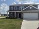 Two-story home with gray siding and a brick facade, enhanced by a well-manicured lawn at 251 Dyson Dr, Whiteland, IN 46184