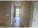 Bright hallway with wood floors and neutral walls leading to the front door and a view of the outdoors at 251 Dyson Dr, Whiteland, IN 46184
