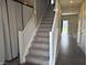 View of carpeted staircase with white railing, leading to the upper level and visible hallway at 251 Dyson Dr, Whiteland, IN 46184