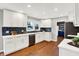 Modern kitchen with white cabinets, dark blue tile backsplash, and hardwood floors at 3015 Olive Branch Rd, Greenwood, IN 46143