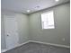 Bright bedroom featuring gray carpet, a window, and a white door at 3153 N Layman Ave, Indianapolis, IN 46218
