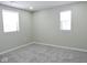 Spacious bedroom with gray carpet and two windows at 3153 N Layman Ave, Indianapolis, IN 46218