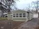 Charming home featuring green siding, a sunroom with lots of windows, and a well-maintained yard at 3153 N Layman Ave, Indianapolis, IN 46218