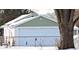 Detached garage with white door and green siding at 3153 N Layman Ave, Indianapolis, IN 46218