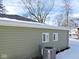 Rear view of house showing green vinyl siding, snow, and trees at 3153 N Layman Ave, Indianapolis, IN 46218