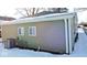Rear view of house with green vinyl siding and snow covered ground at 3153 N Layman Ave, Indianapolis, IN 46218