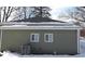 Rear view of house showcasing green vinyl siding and snow covered ground at 3153 N Layman Ave, Indianapolis, IN 46218