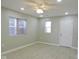 Living room with ceiling fan, grey floor, and white door at 3153 N Layman Ave, Indianapolis, IN 46218
