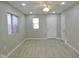 Living room with ceiling fan, grey floor, and white door at 3153 N Layman Ave, Indianapolis, IN 46218
