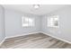 Bright bedroom with gray walls, wood-look floors, and two windows at 328 Elva St, Anderson, IN 46013