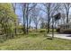 Expansive backyard with a basketball hoop, concrete patio and mature trees, perfect for outdoor activities at 3375 Lincoln Rd, Indianapolis, IN 46222