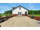 A charming white garage featuring a black door and trim, complemented by a brick wall at 4450 W 300 N, Fairland, IN 46126