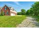 Back of property features an oversized two car garage, ample parking, and mature landscaping at 4450 W 300 N, Fairland, IN 46126