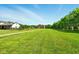 Expansive green lawn surrounding a traditional-style home on a sunny day with trees lining the property at 4450 W 300 N, Fairland, IN 46126