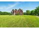 Stately red brick home boasts beautiful columns, a manicured lawn, and charming curb appeal at 4450 W 300 N, Fairland, IN 46126