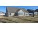 Brick home with a patio, surrounded by a manicured lawn at 4667 W Meadows Ln, New Palestine, IN 46163
