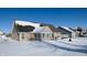 Home's back features a patio, surrounded by a snowy yard at 4667 W Meadows Ln, New Palestine, IN 46163