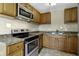 Galley kitchen with stainless steel appliances and wood cabinets at 5201 N White Ln, Lawrence, IN 46226