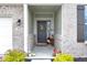 Inviting front porch with a decorative door, potted plants, and brick accents at 5670 Terracotta Trce, McCordsville, IN 46055