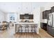 An open-concept kitchen with a large island featuring seating, seamlessly flowing into the dining area at 5670 Terracotta Trce, McCordsville, IN 46055