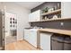 Well-organized laundry room with a washer, dryer, counter, and shelves for efficient cleaning and storage at 5670 Terracotta Trce, McCordsville, IN 46055