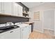Modern laundry room with white cabinets, shelves, and updated washer and dryer units for convenience at 5670 Terracotta Trce, McCordsville, IN 46055