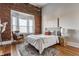 Charming bedroom featuring exposed brick wall, large window, and cozy decor at 643 Fort Wayne Ave # H, Indianapolis, IN 46204