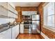 Well-equipped kitchen with exposed brick, stainless steel appliances, and white cabinetry at 643 Fort Wayne Ave # H, Indianapolis, IN 46204