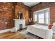 Stylish main bedroom featuring exposed brick, fireplace, and ample natural light at 643 Fort Wayne Ave # H, Indianapolis, IN 46204