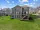 Spacious backyard featuring a wooden deck, grassy lawn, and trampoline at 6711 Colville Pl, Indianapolis, IN 46236