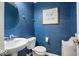 Small powder room with blue walls, white sink, and toilet at 6711 Colville Pl, Indianapolis, IN 46236